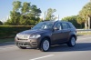 Driving 2013 BMW X5 xDrive50i in Sparkling Bronze Metallic from a front left three-quarter view